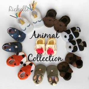 May include: A collection of animal-themed baby booties. The booties are made of soft fabric and feature various animal designs, including a unicorn, a panda, a fox, a bunny, and a monkey. The booties are arranged in a circle on a white background.