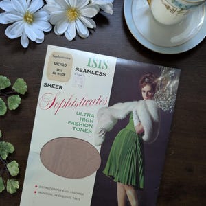 May include: A vintage package of "Sophisticates" sheer nylon stockings in "Spicyglo" colour. The package features a retro illustration of a woman in a green dress and white fur stole. The package also includes text: "ISIS SEAMLESS" and "ULTRA HIGH FASHION TONES."