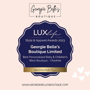 May include: A navy blue award badge with white text, featuring the words "LUXlife Style & Apparel Awards 2023" and "Georgie Belle's Boutique Limited". The badge is for "Best Personalised Baby & Children's Wear Boutique - Cheshire". The word "winner" is also visible.