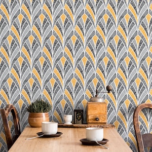 May include: A dining room scene featuring a wooden table set with two white cups and saucers. The background showcases a wallpaper with a repeating fan-like pattern in gray, yellow, and white. A coffee grinder and potted plant are also visible.