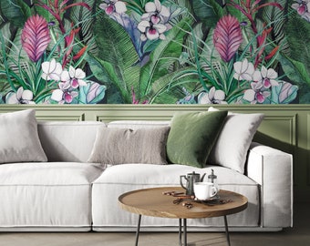 May include: A white sofa with green pillows sits in front of a wall covered in tropical wallpaper. The wallpaper features large green leaves, pink flowers, and white orchids.