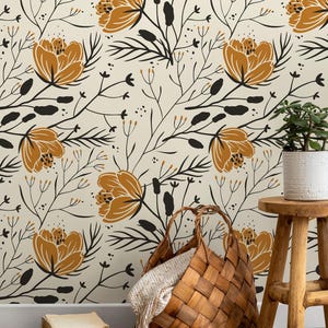 May include: A floral wallpaper design featuring large, stylized orange flowers and black foliage against a cream background. A woven basket with a blanket, a small wooden stool, and a potted plant are in the foreground.