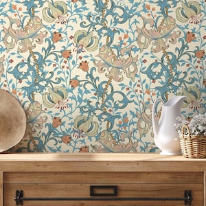 May include: Floral wallpaper featuring a repeating pattern of stylized lilies in shades of blue, peach, and cream. A white pitcher and a small wicker basket with white flowers sit on a wooden surface.