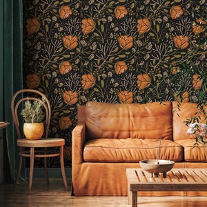May include: A room featuring floral wallpaper in black, orange, and gold hues. A brown leather sofa and wooden chair are positioned in front of the wallpaper. A wooden coffee table and a potted plant are also present.