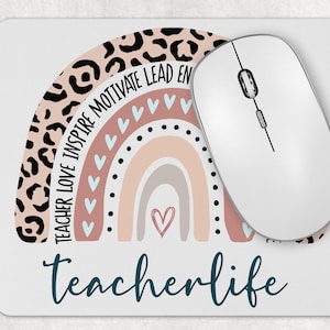 May include: A pink and brown rainbow with a leopard print design and the text "Teacher Love Inspire Motivate Lead Empower" around the top arc. The rainbow has a white heart in the center and the text "teacherlife" in teal blue at the bottom.