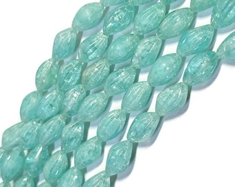 May include: A strand of light blue faceted glass beads. The beads are oval shaped and have a textured surface.