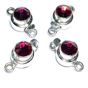 Pode incluir: Quatro fechos de correr prateados com detalhes de strass vermelho. Cada fecho tem dois laços para prender joias.