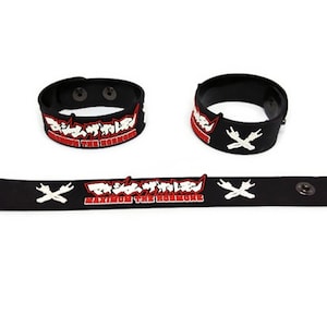 以下が含まれることがあります： 白と赤の文字が入った黒いシリコンブレスレット3本。ブレスレットには、日本語で「マキシマムザホルモン」というバンド名と、英語で「Maximum the Hormone」という文字が書かれている。1本のブレスレットには、白い電気プラグ2本が交差したグラフィックが描かれている。