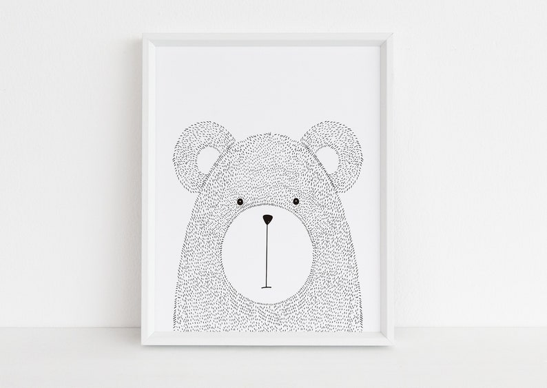 May include: A framed black and white illustration of a bear's face. The bear's body is filled with small dots, and it has large, round ears. The artwork is in a white frame, suitable for a nursery or children's room.