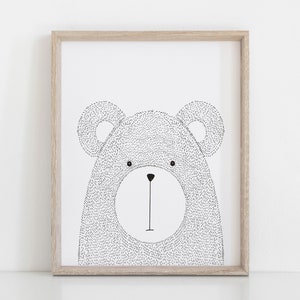 May include: A framed art print featuring a black and white illustration of a bear's face. The bear is drawn with a dotted texture, and the artwork is set within a light brown wooden frame. The bear has a simple, minimalist design.
