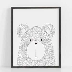 May include: A framed black and white illustration of a bear's face. The bear is drawn with small dots, giving it a textured appearance. The artwork is simple and modern, suitable for a nursery or children's room.