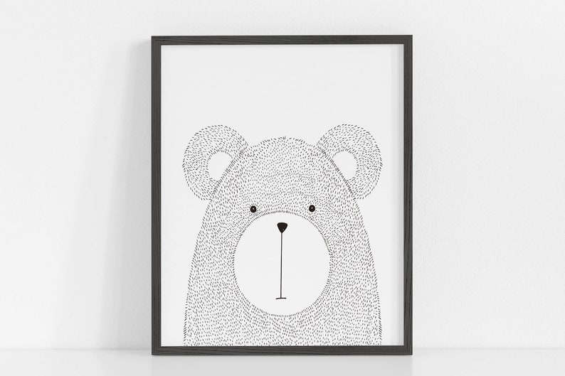 May include: A framed black and white illustration of a bear's face. The bear is drawn with small dots, giving it a textured appearance. The artwork is simple and modern, suitable for a nursery or children's room.