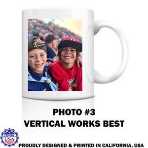 May include: White ceramic mug with a photo of two boys smiling at the camera. The boy on the left is wearing a blue scout uniform and the boy on the right is wearing a red shirt and a baseball cap. The text "PHOTO #3 VERTICAL WORKS BEST" is printed below the photo.