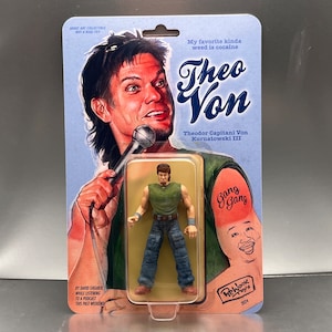 May include: A collectible action figure of Theo Von, packaged on a light blue card. The card features an illustration of Theo Von with a microphone, the text "Theo Von", and the phrase "My favorite kinda weed is cocaine."
