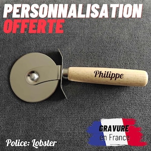 Peut inclure: Une roulette à pizza avec un manche en bois gravé du nom "Philippe". La lame est argentée, et le texte "PERSONNALISATION OFFERTE" est en haut. Le texte "GRAVURE en France" est en bas.