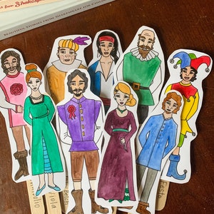 Puede incluir: Un conjunto de 10 recortes de personajes pintados a mano de las obras de Shakespeare. Cada recorte está en un palo de madera con el nombre del personaje escrito en él. Los personajes incluyen Viola, Orsino, Sebastian, Feste, Olivia, Malvolio, Sir Toby Belch, Sir Andrew Aguecheek y el Duque.