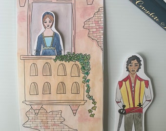 Peut inclure: Une illustration dessinée à la main d'une scène de balcon avec une femme en robe bleue regardant par une fenêtre et un homme en costume jaune et rouge debout en dessous. L'illustration est sur un bâton de sucette avec le mot "Roméo" écrit sur le bâton.