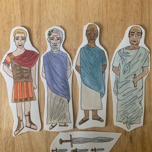 May include: Four paper cutouts of men in different historical costumes. The men are wearing a Roman soldier outfit, a toga, a blue tunic, and a white toga. There are also four paper cutouts of swords.