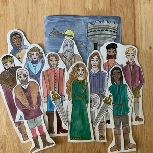 Könnte beinhalten: Ein Set aus zehn handbemalten Papppuppen, die Figuren aus einer mittelalterlichen Geschichte darstellen. Die Puppen sind in farbenfrohe Kleidung gekleidet und haben detaillierte Gesichtszüge. Die Puppen sind vor dem Hintergrund eines dunkelblauen Himmels mit Mond und Burg platziert.