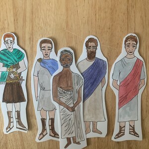 May include: Five paper cut-outs of men wearing different styles of clothing. The men are drawn in a cartoon style with watercolour paint. The men are wearing a variety of colours, including green, blue, red, and brown.