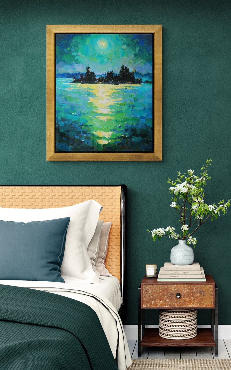 May include: A bedroom interior with a green wall, a bed with a green and white comforter, a nightstand with a vase of white flowers, and a framed painting of a moonlit lake scene.