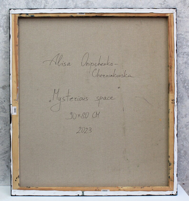 Peut inclure: L'arri&egrave;re d'une toile encadr&eacute;e avec la signature de l'artiste, "Alisa Onischenko-Cherniavska", et le titre, "Mysterious space", &eacute;crits &agrave; l'encre noire. Les dimensions de la peinture sont indiqu&eacute;es comme &eacute;tant "90x80 CM" et l'ann&eacute;e "2023" est &eacute;galement &eacute;crite sur la toile.