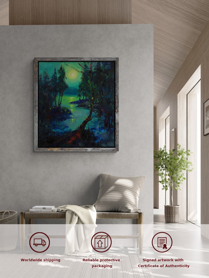 Peut inclure: Une peinture encadr&eacute;e repr&eacute;sentant une sc&egrave;ne de for&ecirc;t &eacute;clair&eacute;e par la lune avec une rivi&egrave;re qui la traverse. La peinture est dans un cadre en bois rustique et est accroch&eacute;e &agrave; un mur gris. La peinture est entour&eacute;e d'un mur gris clair, d'un banc en bois, d'une couverture et d'une plante en pot.