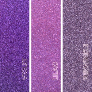 May include: Three vertical panels of glitter in shades of purple. The left panel is labeled "VIOLET", the middle panel is "LILAC", and the right panel is "PERIWINKLE". The glitter has a fine texture and reflects light.