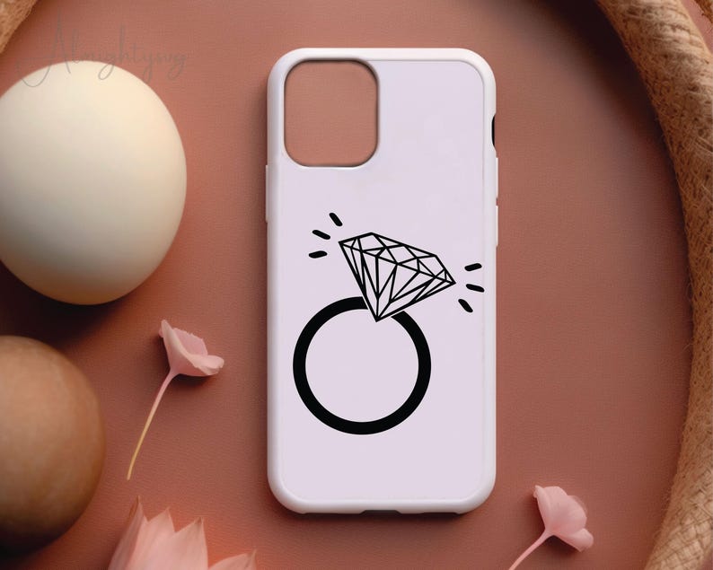 Pode incluir: Capa de telefone branca com um design de anel de diamante preto. O anel &eacute; contornado em preto e tem uma forma de diamante no centro.