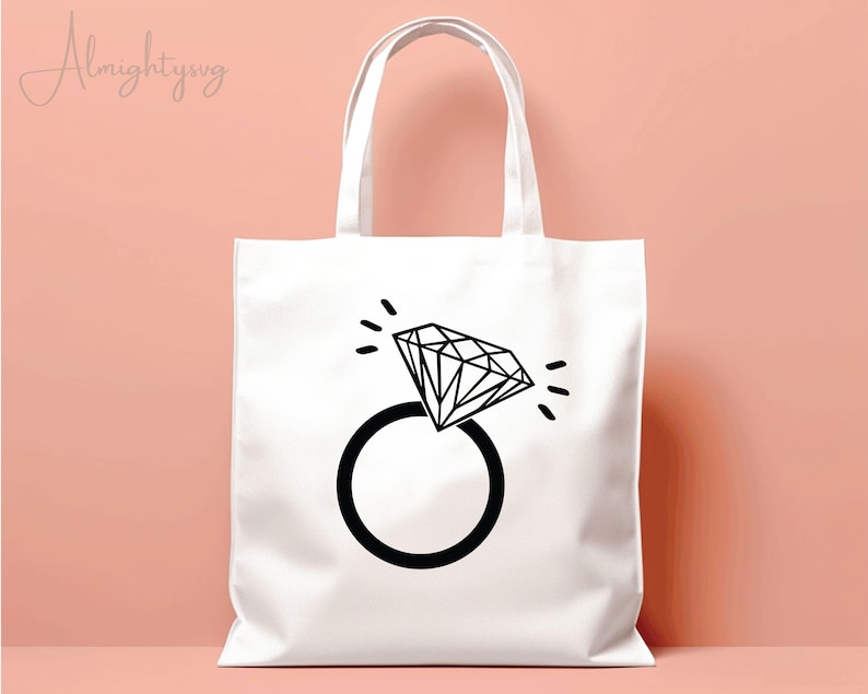 Pode incluir: Sacola branca com um gr&aacute;fico de anel de diamante preto. O anel tem um diamante grande com uma ponta pontiaguda e uma banda simples.