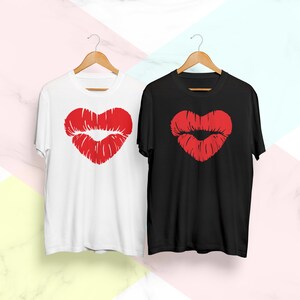 May include: Two t-shirts with a red heart-shaped lips design. One t-shirt is white and the other is black.