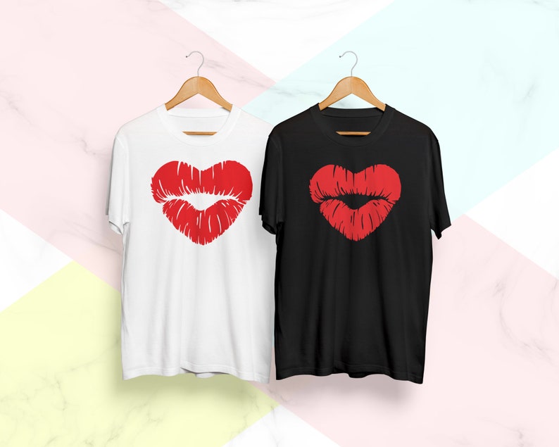 May include: Two t-shirts with a red heart-shaped lips design. One t-shirt is white and the other is black.