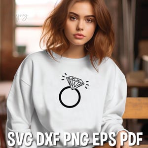 Pode incluir: Uma camisa de moletom branca com um gr&aacute;fico preto de um anel de diamante. O gr&aacute;fico est&aacute; centralizado na camisa de moletom.