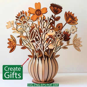 May include: Wooden laser cut flower bouquet with a vase. The flowers are in shades of brown and orange. The vase is made of wood and has a striped pattern.