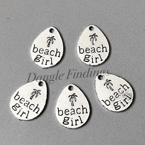 May include: Five silver charm pendants with a teardrop shape. Each charm features a palm tree and the text "beach girl".