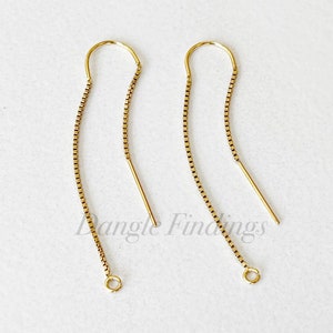 May include: Two gold dangle earring findings with a chain link design and a jump ring at the bottom.