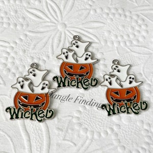 Pode incluir: Tr&ecirc;s pingentes de prata com um design de ab&oacute;bora com cara de jack-o'-lantern e tr&ecirc;s fantasmas dentro. A ab&oacute;bora &eacute; laranja com um caule verde e a palavra "Wicked" escrita em letras verdes abaixo da ab&oacute;bora.