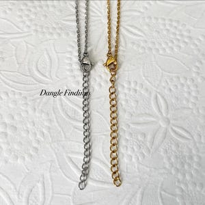May include: Two silver and gold chains with lobster claw clasps. The chains are both about 18 inches long.