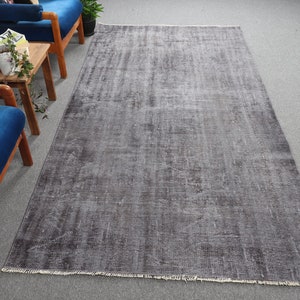 May include: A gray and white distressed area rug with a subtle pattern. The rug has a fringed edge.