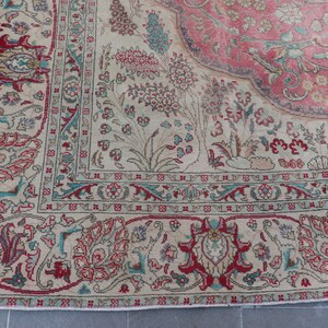 Puede incluir: Una alfombra vintage con fondo crema y un medall&oacute;n central en tonos rosa y rojo. La alfombra presenta intrincados patrones florales y geom&eacute;tricos en tonos azul, verde y rojo.
