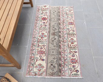 May include: A beige runner rug with a traditional floral pattern in shades of red, pink, and brown. The rug has a fringed edge and is approximately 2 feet wide and 6 feet long.