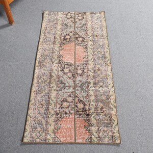 May include: A vintage runner rug with a pink, brown, and cream floral pattern. The rug has a distressed look and is perfect for adding a touch of bohemian style to your home.