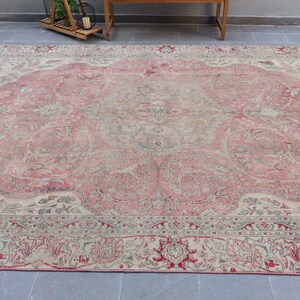 Puede incluir: Una alfombra vintage con un esquema de color rosa y crema. La alfombra tiene un patr&oacute;n floral con intrincados detalles. La alfombra est&aacute; en buen estado y tiene un aspecto desgastado.