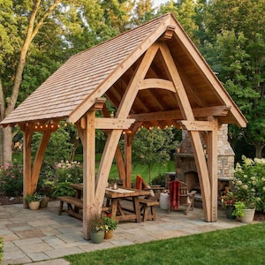 Può includere: Un gazebo in legno con tetto a capanna, un tavolo e panche. La struttura è realizzata in legno chiaro e ha un camino in pietra. Le luci della stringa sono appese lungo la linea del tetto e il gazebo è circondato dal verde.