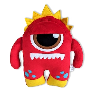 Könnte beinhalten: Rotes Plüschmonster-Spielzeug mit einem großen Auge, gelbem, stacheligem Haar und einem breiten Grinsen. Das Monster hat blaue und gelbe Akzente auf seinem Körper.