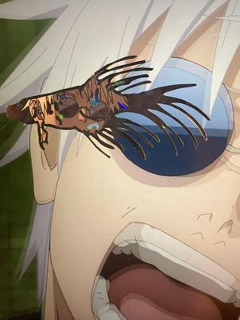 May include: A close-up of an anime character's face with a decorative, stylized headpiece. The headpiece is brown and black with spiky extensions and iridescent accents. The character's eye is partially visible, with a blue and white background.