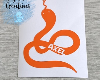 Pode incluir: Adesivo de vinil laranja de uma cobra com o nome Axel escrito dentro do corpo da cobra.