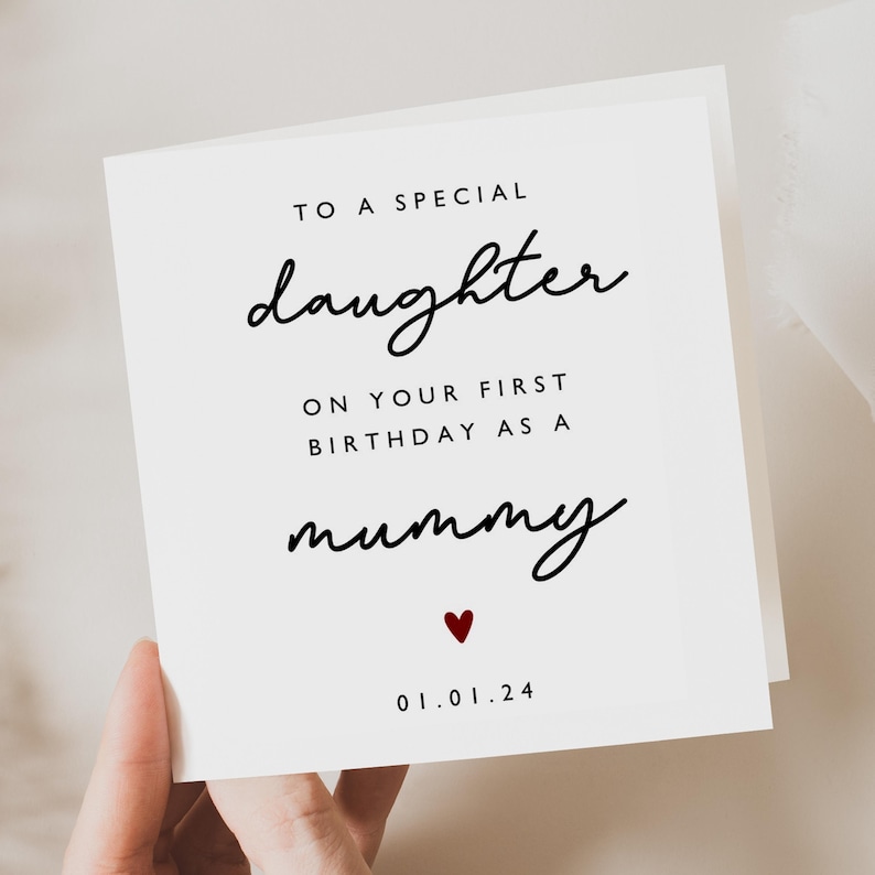 May include: A white card with black text that reads "To a special daughter on your first birthday as a mummy" with a small red heart and the date "01.01.24" printed below.