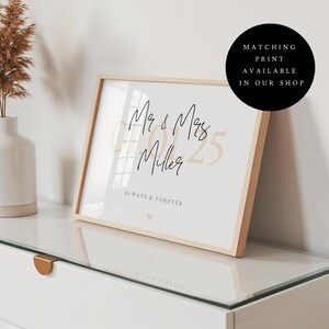 May include: A framed print in a light wood frame featuring the text Mr & Mrs Miller, the date 07.01.25 in large beige font, and the text ALWAYS & FOREVER with a small heart icon. A black circular badge states MATCHING PRINT AVAILABLE IN OUR SHOP.