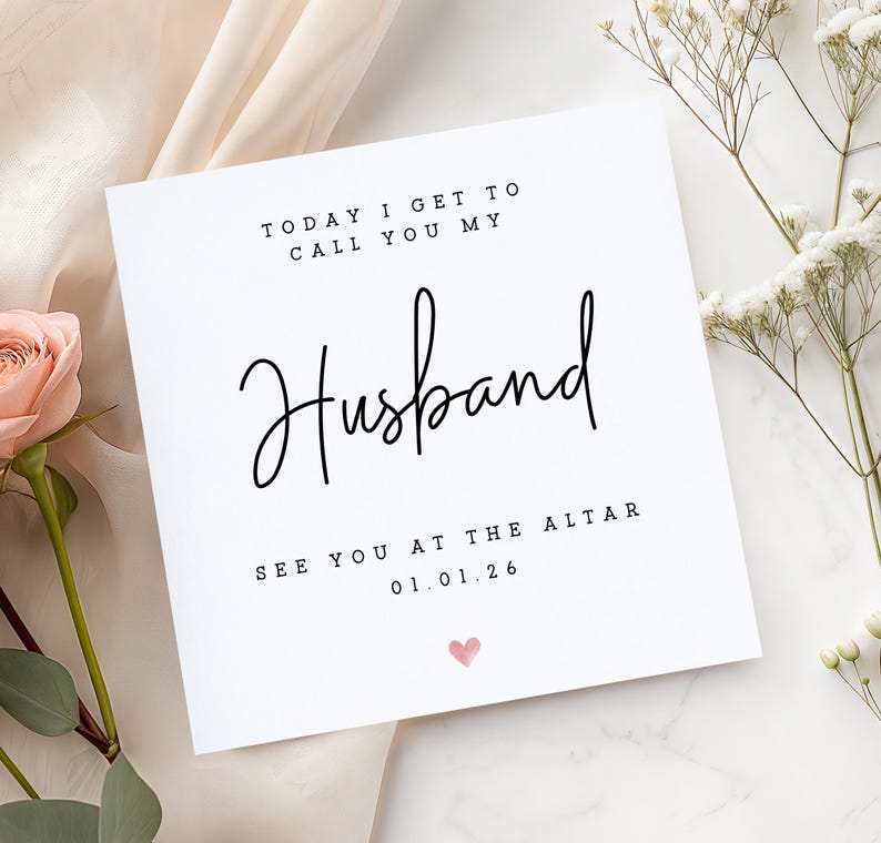 May include: A white square card with the words "TODAY I GET TO CALL YOU MY Husband" in black script. Below, it reads "SEE YOU AT THE ALTAR 01.01.26" with a small pink heart. The card is decorated with flowers.